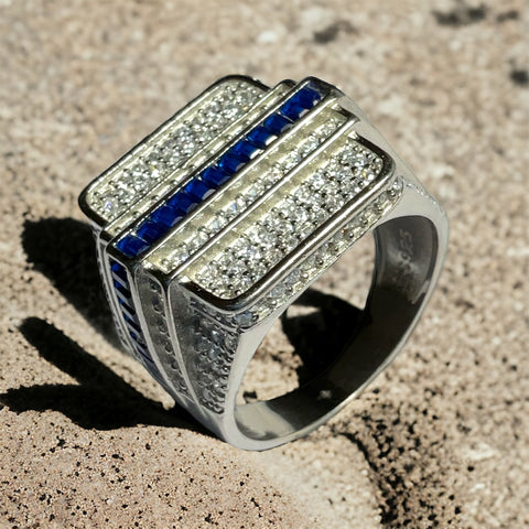a diamond and sapphire ring sitting on a rock