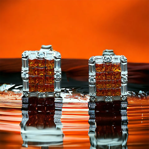 a close up of a pair of earrings on a reflective surface