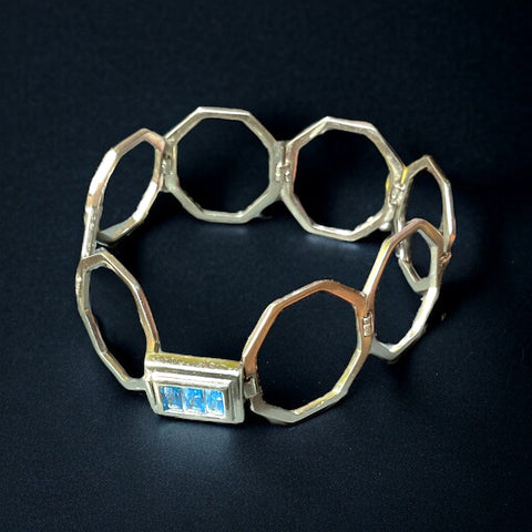 a silver bracelet with a blue logo on it