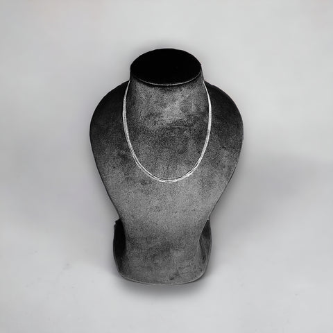 a black and white photo of a necklace on a mannequin