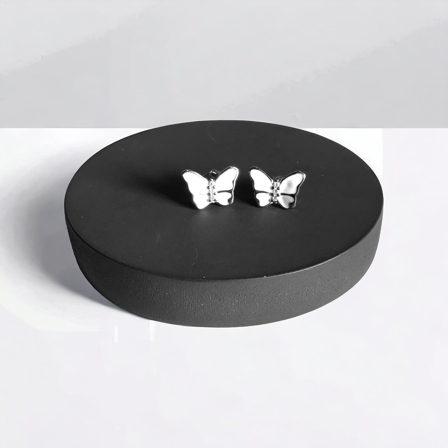 a pair of silver butterflies sitting on top of a black box