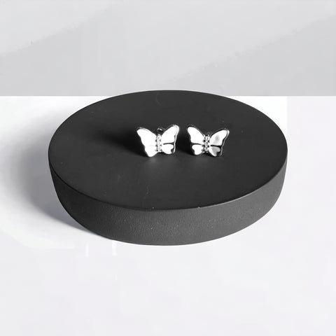a pair of silver butterflies sitting on top of a black box