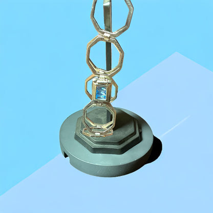 a metal object with a blue diamond on top of it