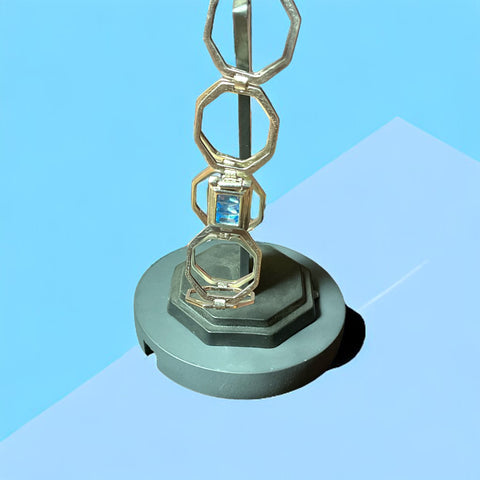 a metal object with a blue diamond on top of it