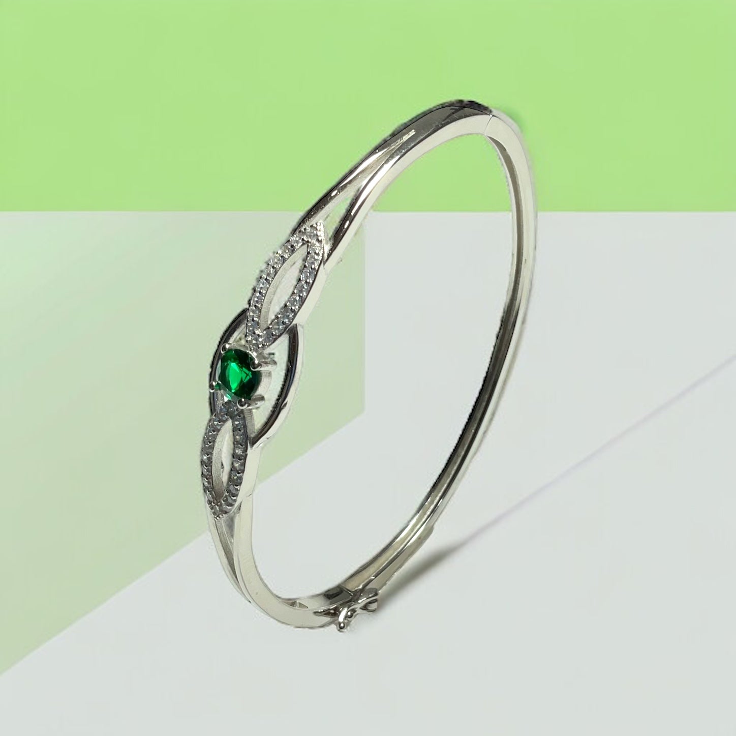 a white gold ring with a green stone
