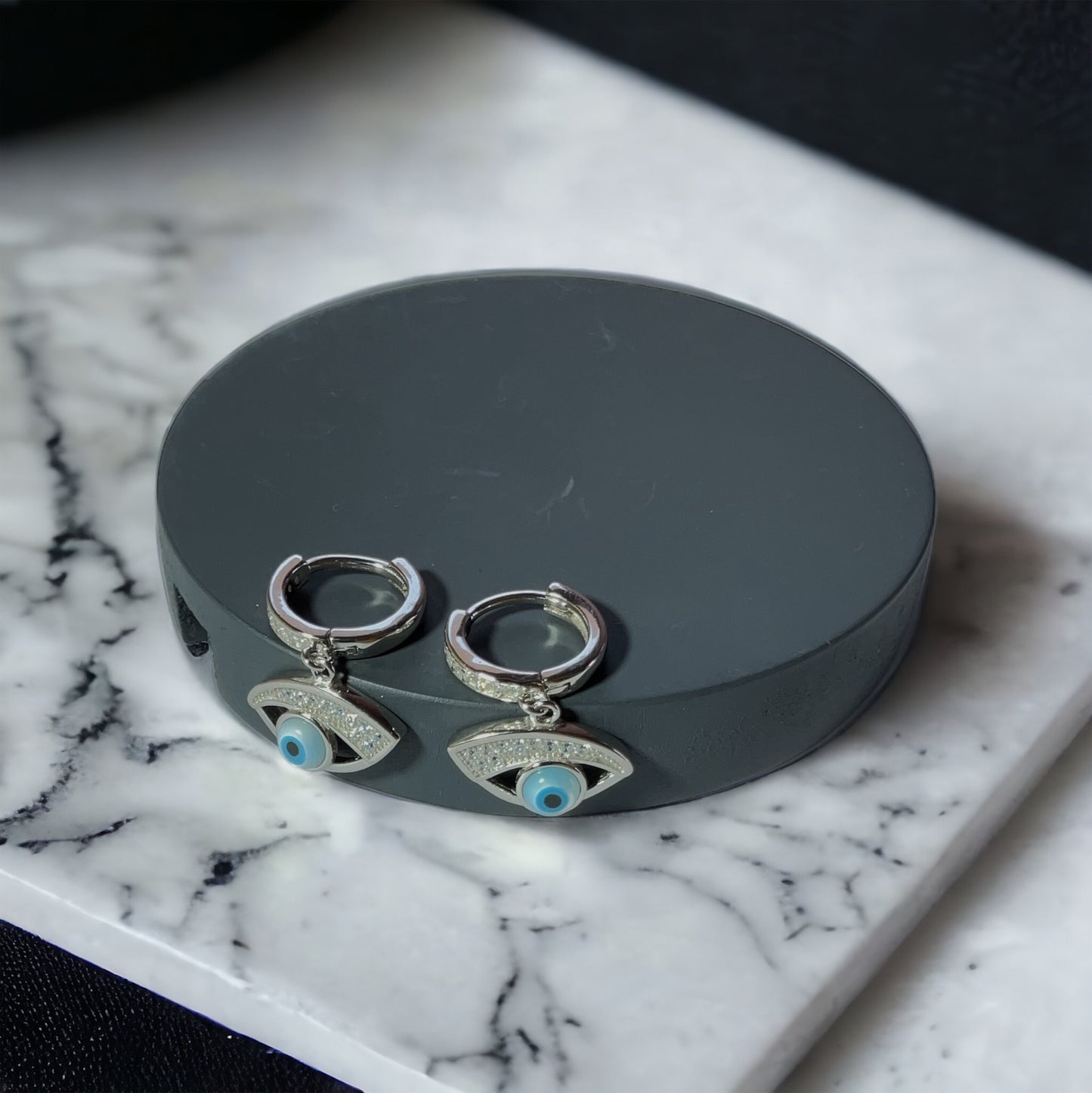 a pair of earrings sitting on top of a marble counter