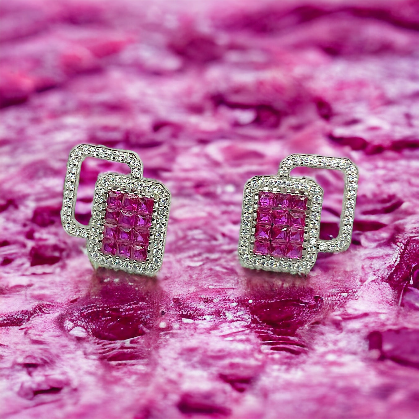 a pair of pink and white diamond earrings