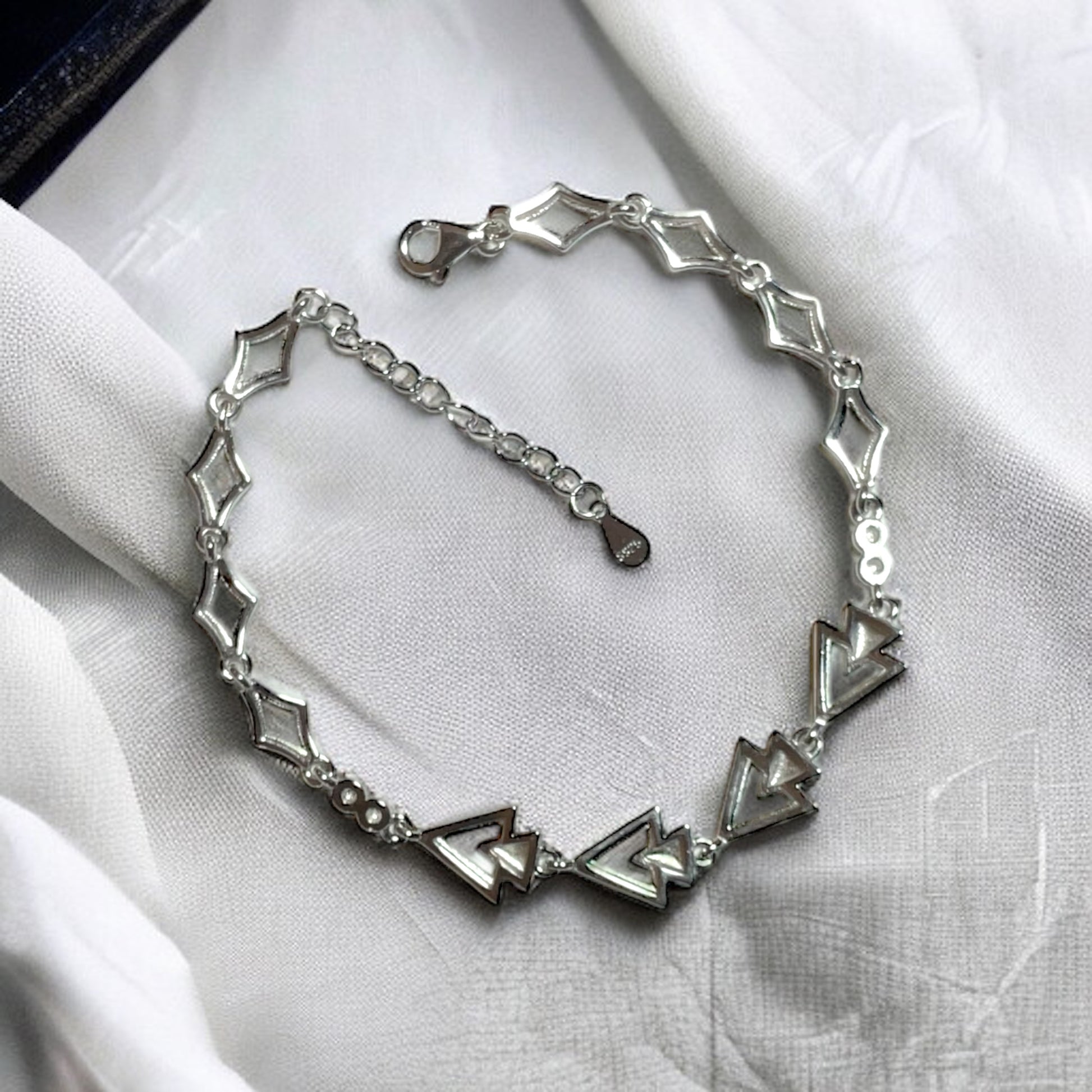 a close up of a bracelet on a white cloth