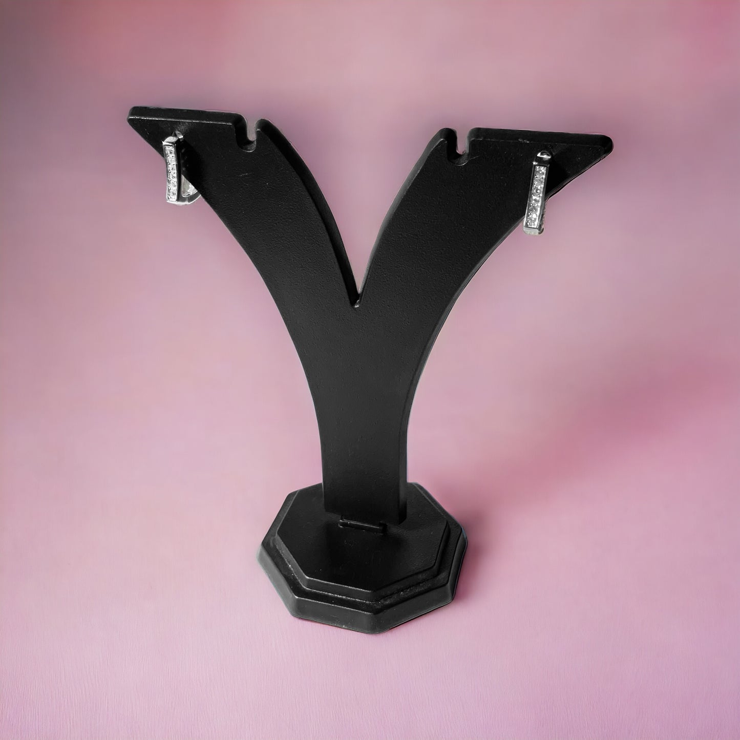 a pair of black metal brackets on a pink background