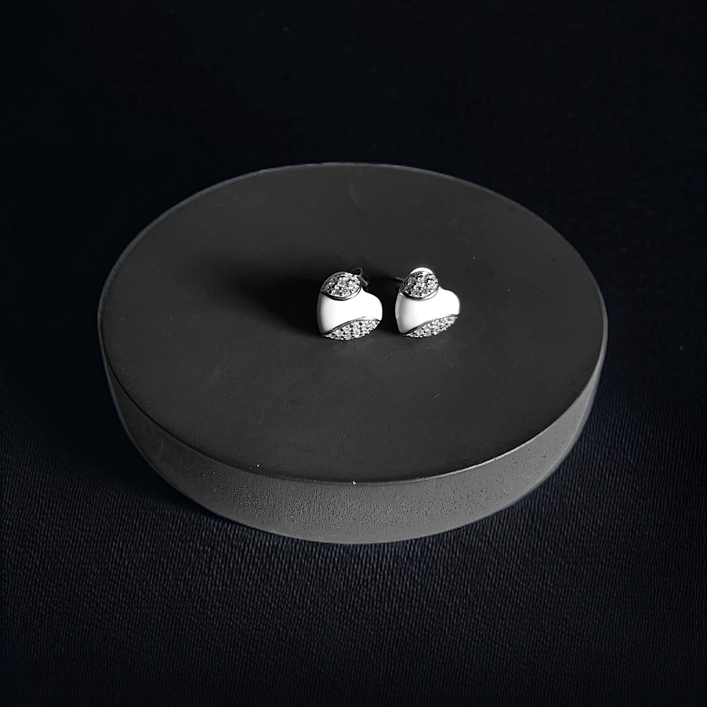 a pair of earrings sitting on top of a black plate