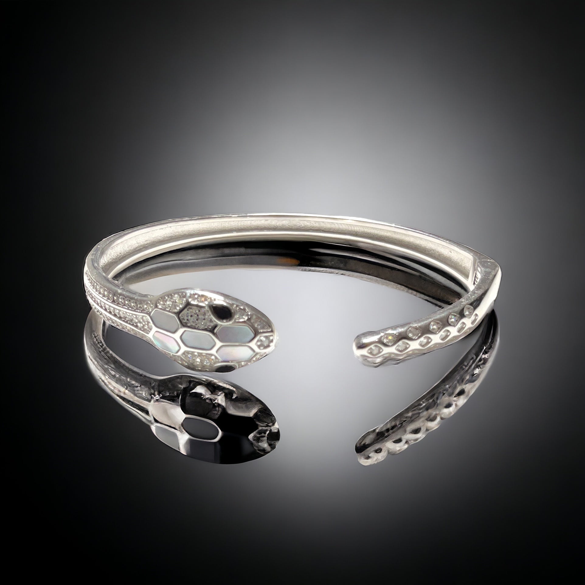 a silver bracelet with a snake design on it