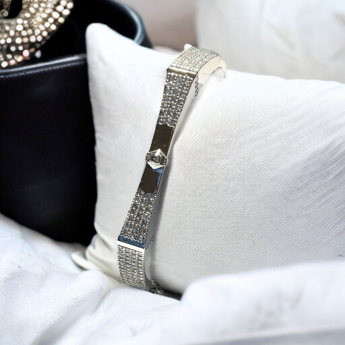 a watch sitting on a pillow next to a purse