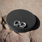 a pair of silver rings sitting on top of a black box