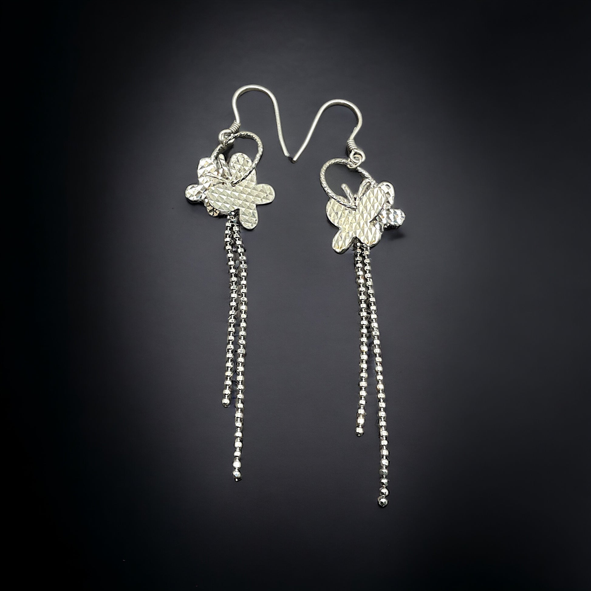 a pair of silver earrings with dangling beads