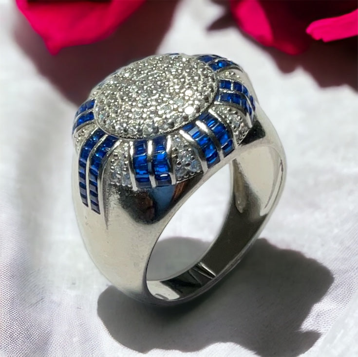 a close up of a ring with a flower in the background