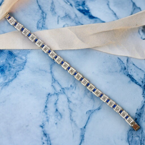 a diamond bracelet laying on a marble surface