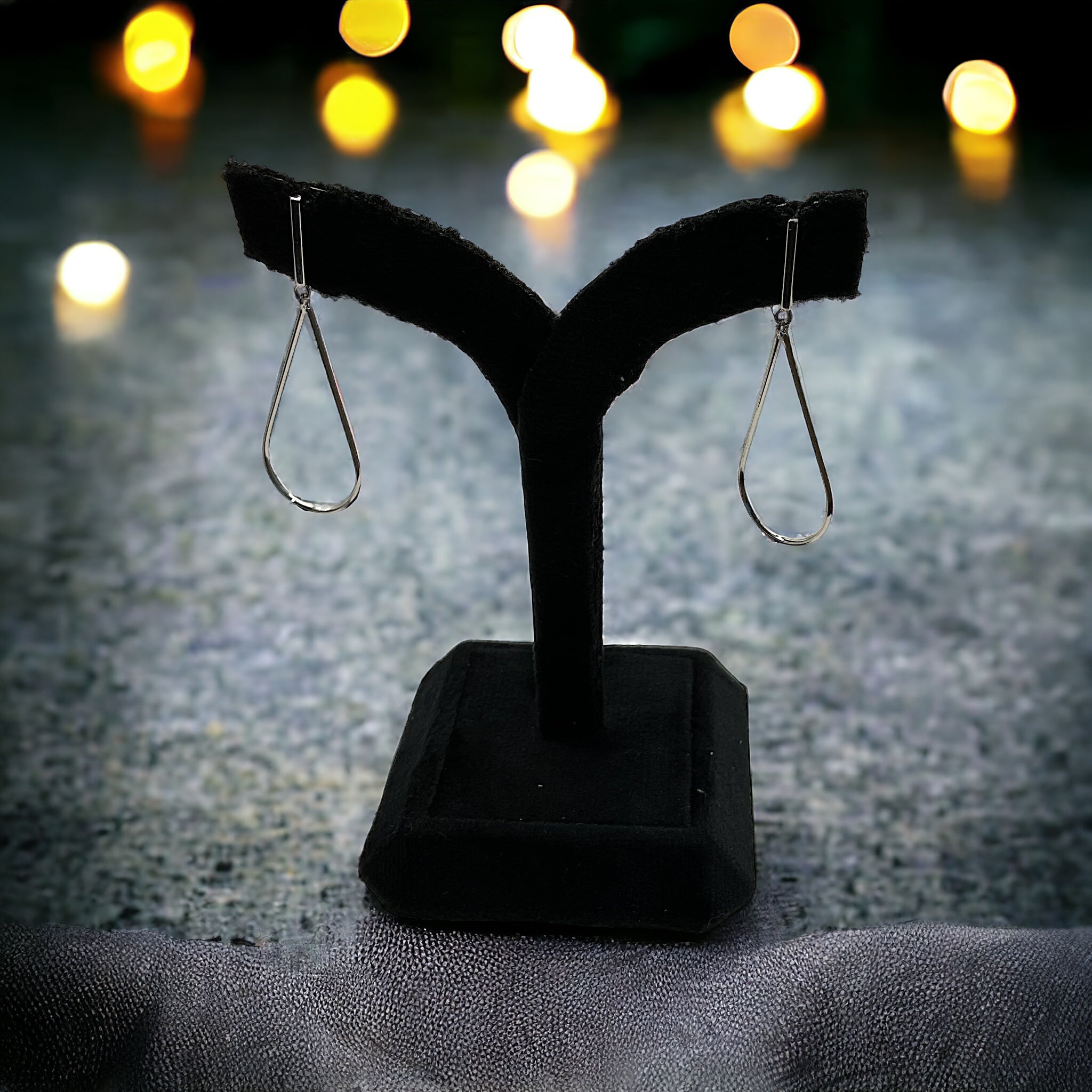 a pair of earrings on a stand on a table