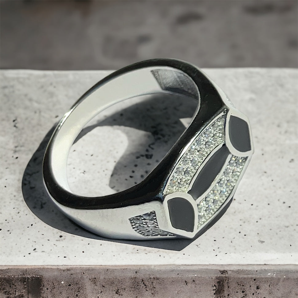 a black and white ring sitting on top of a cement slab