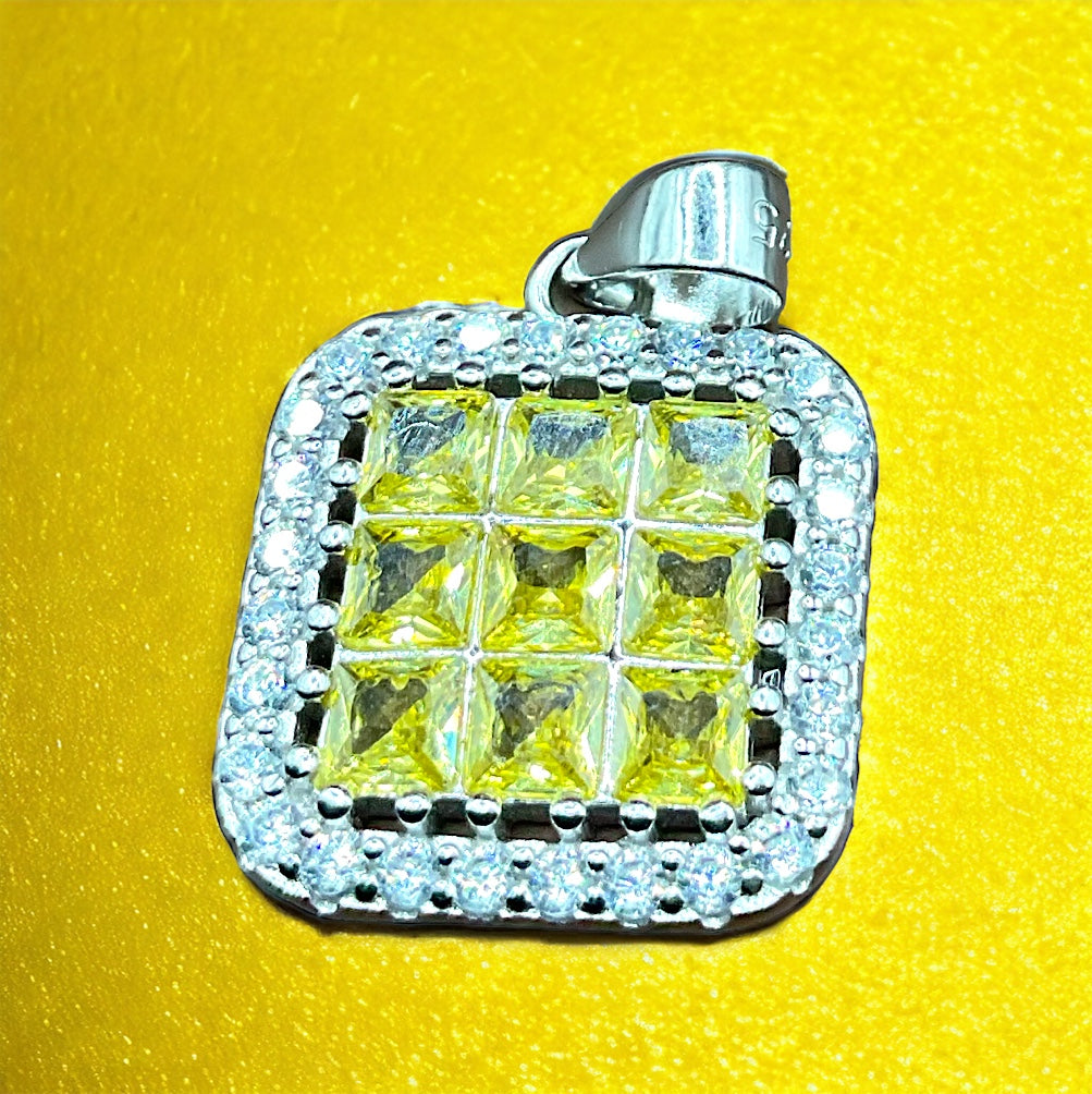 a yellow and white diamond pendant on a yellow surface