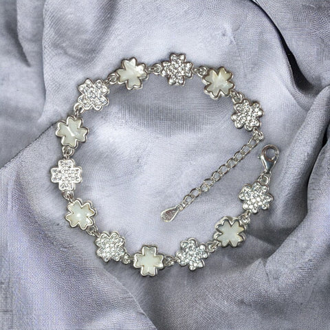a silver bracelet with four leaf clover charms