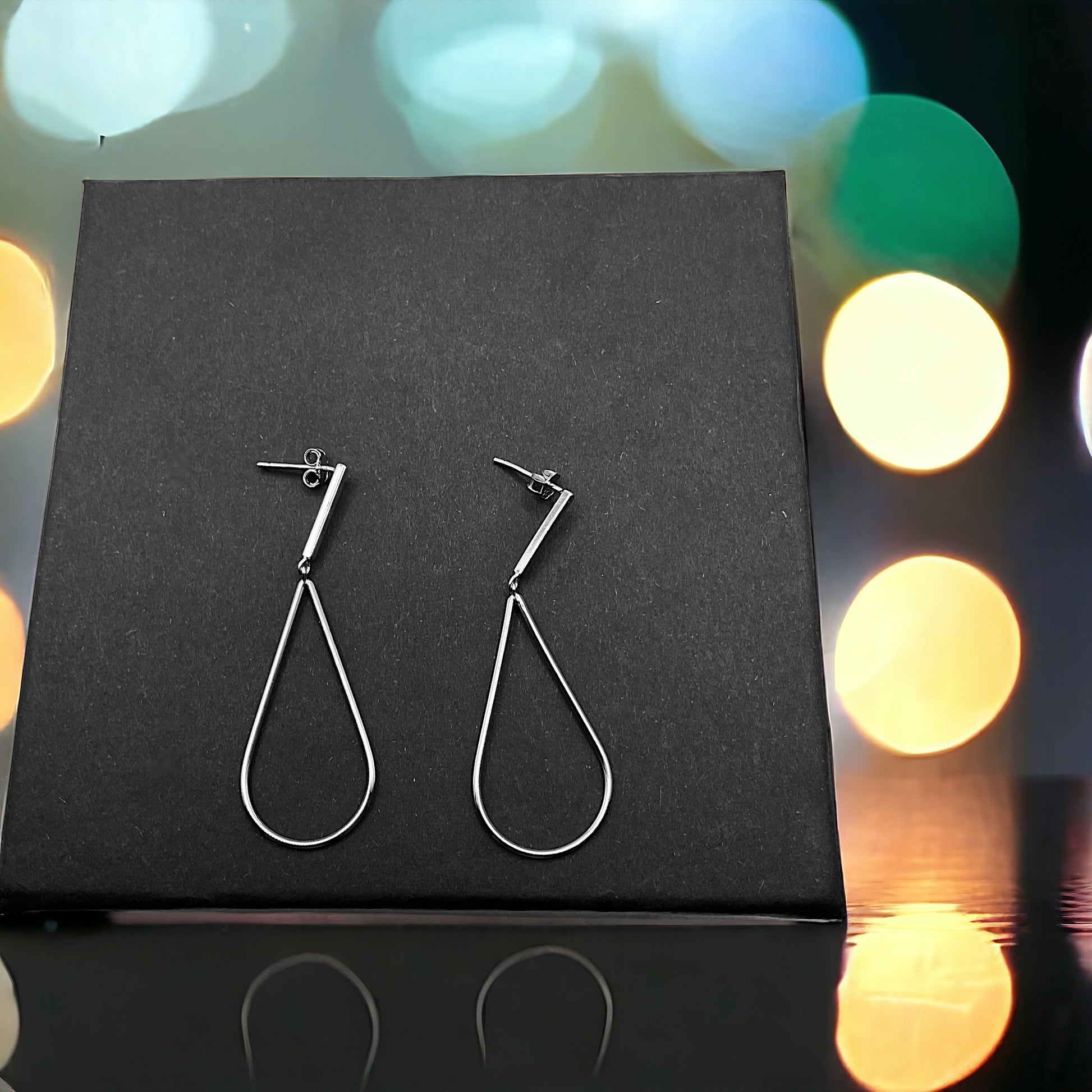 a pair of earrings sitting on top of a black box