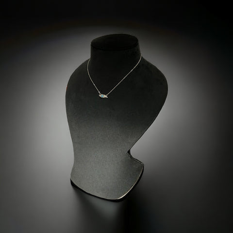 a necklace on a mannequin on a black background