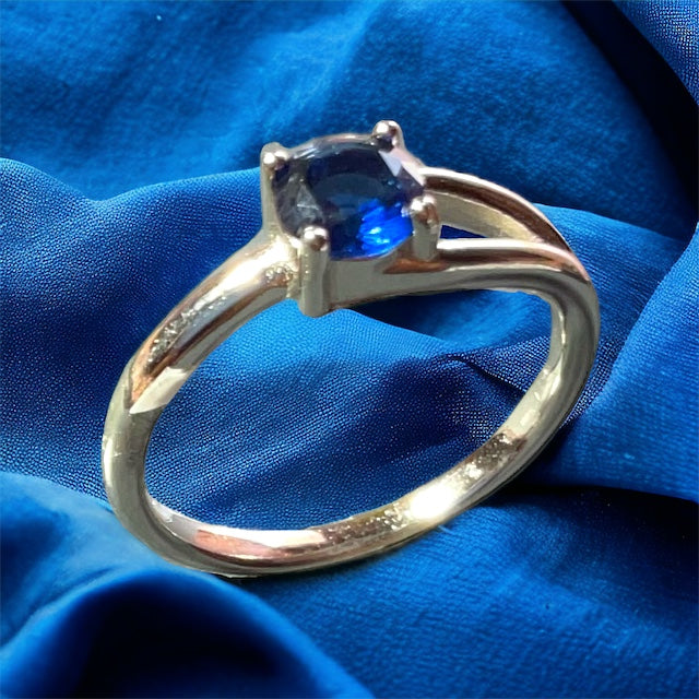 a gold ring with a blue stone on it