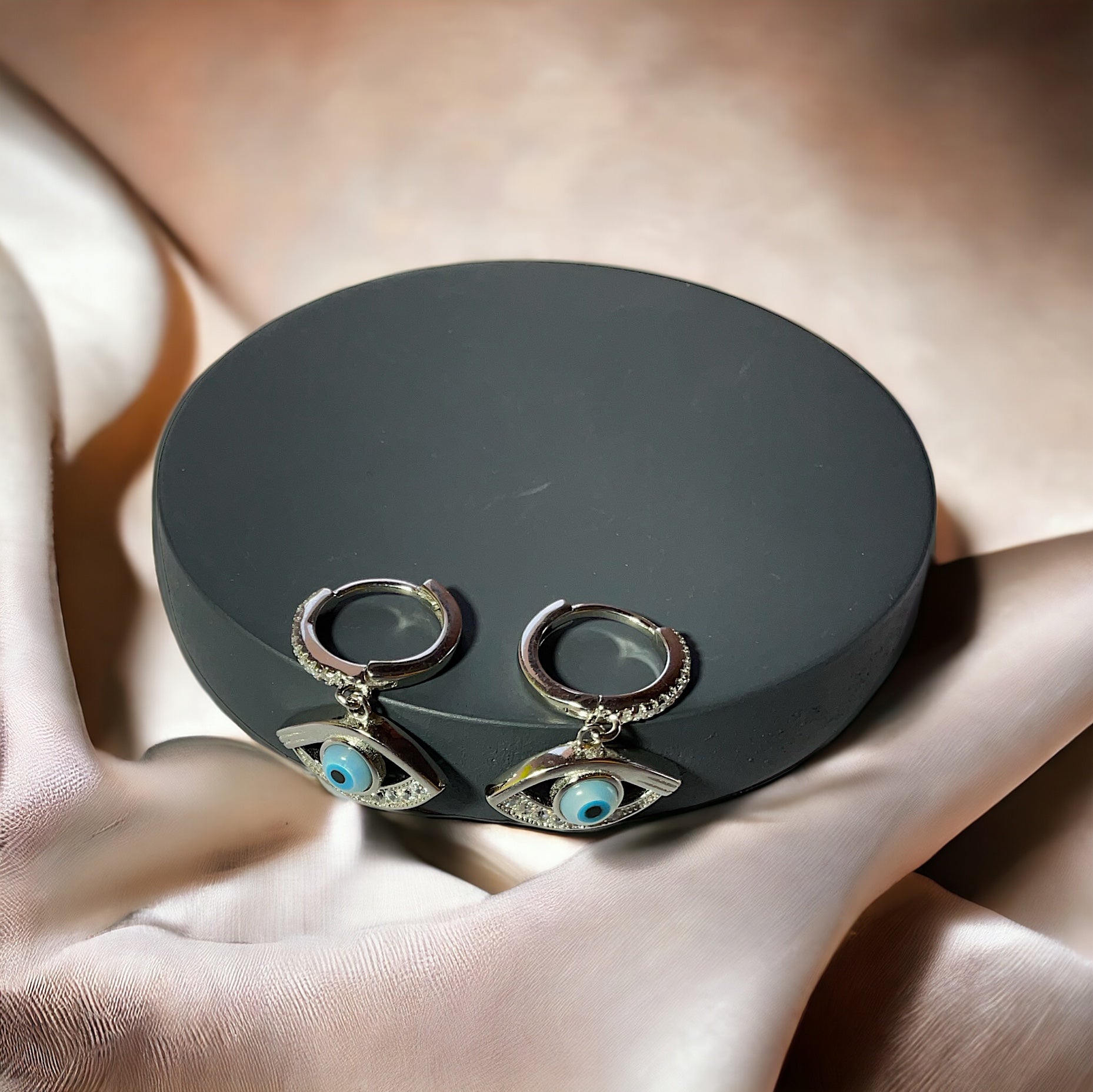 a pair of earrings sitting on top of a black box