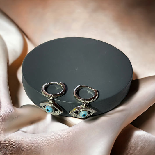 a pair of earrings sitting on top of a black box