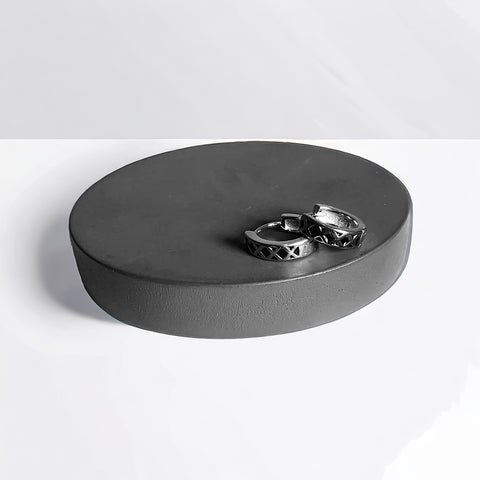 a pair of silver rings sitting on top of a round box