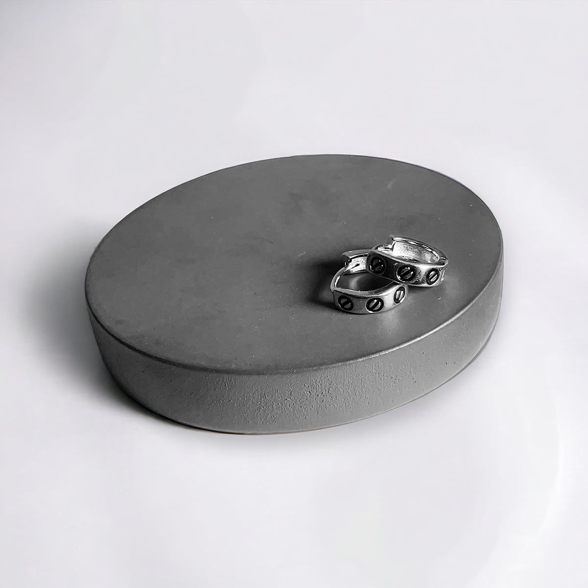 a round metal object with a small metal object on top of it