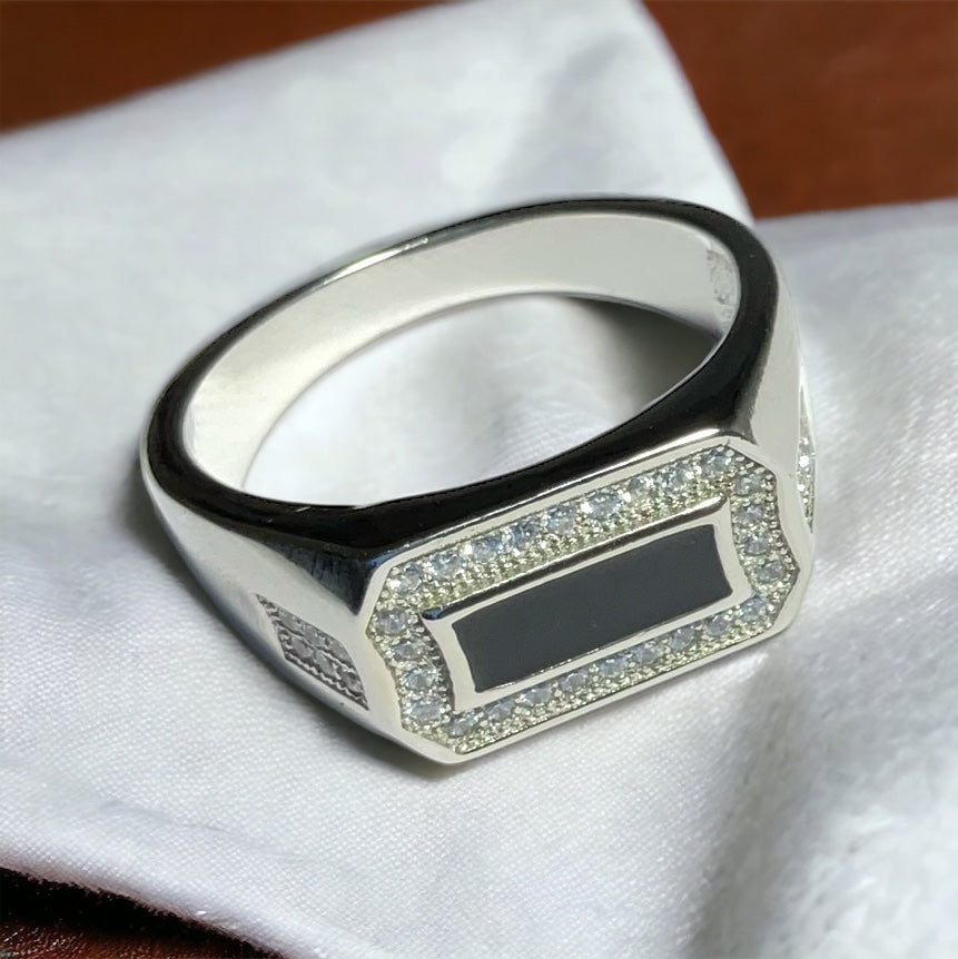 a black and white ring sitting on top of a white cloth