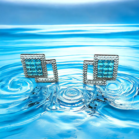 a pair of blue diamond earrings floating in water