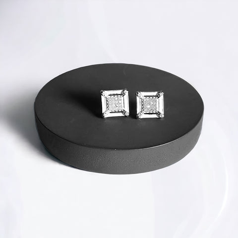a pair of diamond earrings sitting on top of a black box