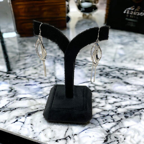 a pair of earrings on display on a marble table