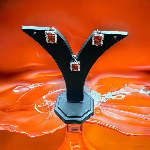 a close up of a pair of earrings on an orange background