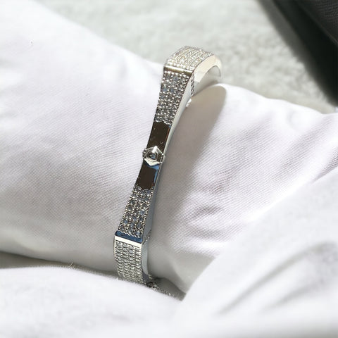 a diamond bracelet sitting on top of a white pillow