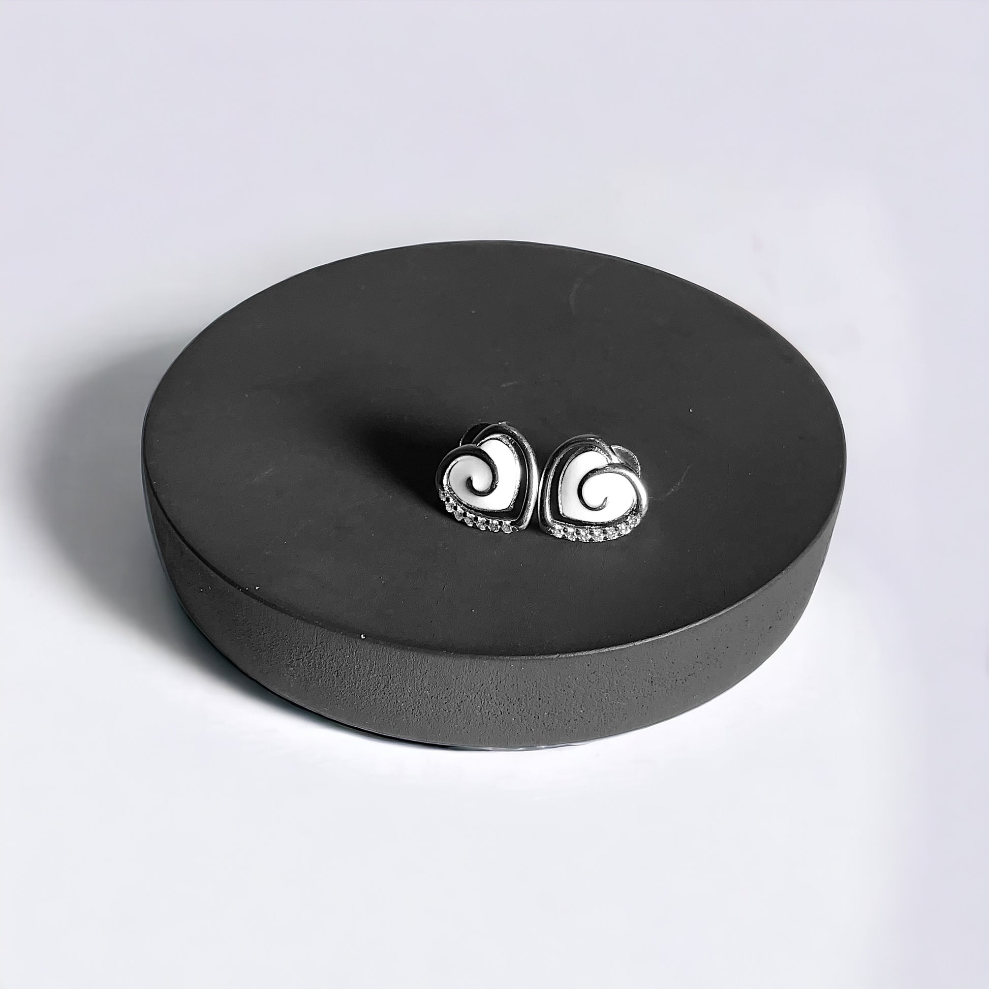 a pair of earrings sitting on top of a black box