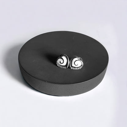 a pair of earrings sitting on top of a black box