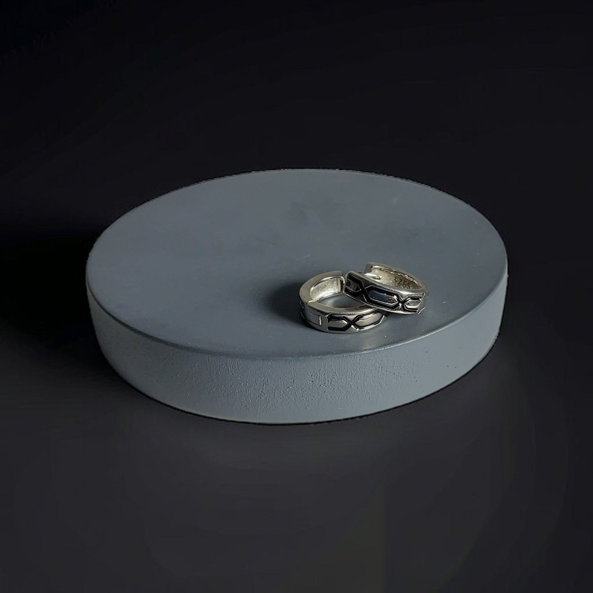 two silver rings sitting on top of a white box