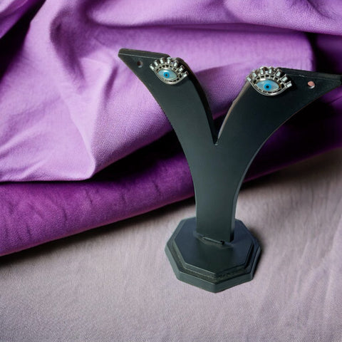 a pair of earrings sitting on top of a black stand