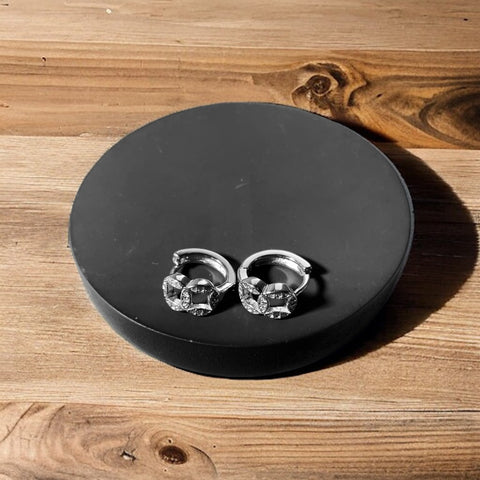a pair of skull earrings sitting on top of a wooden table
