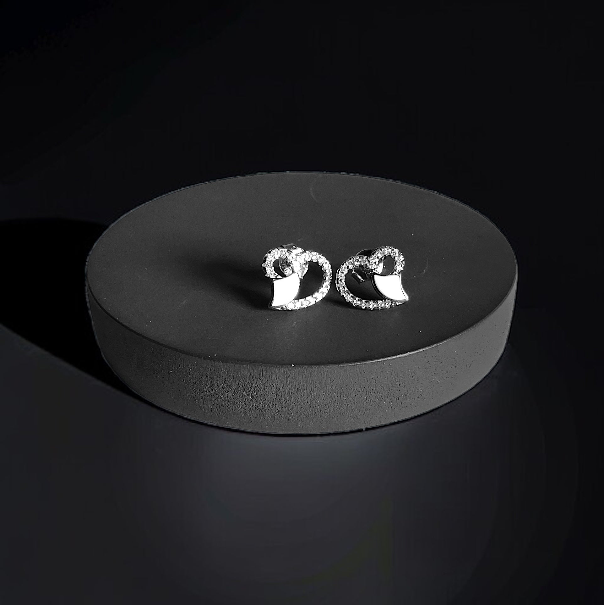 a pair of earrings sitting on top of a black box