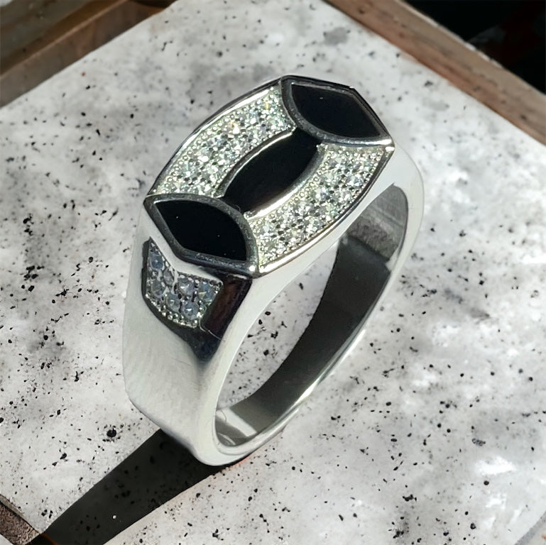 a silver ring with black and white stones on it