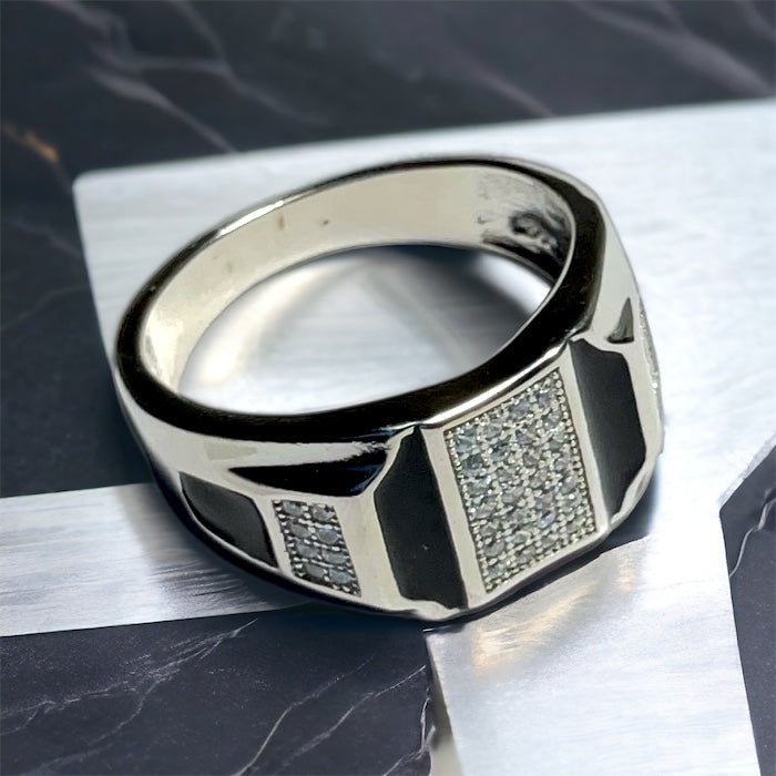 a men's ring sitting on top of a table