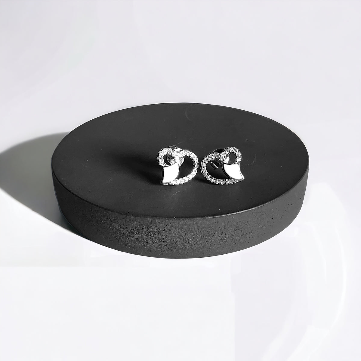 a pair of earrings sitting on top of a black box