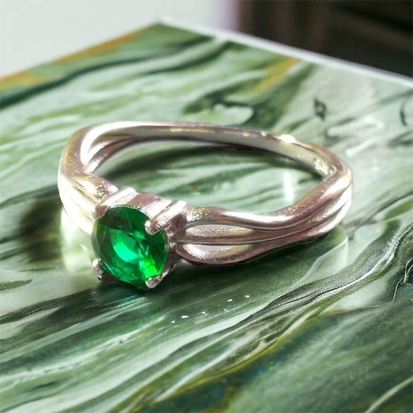 a close up of a ring with a green stone