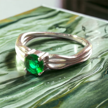 a close up of a ring with a green stone