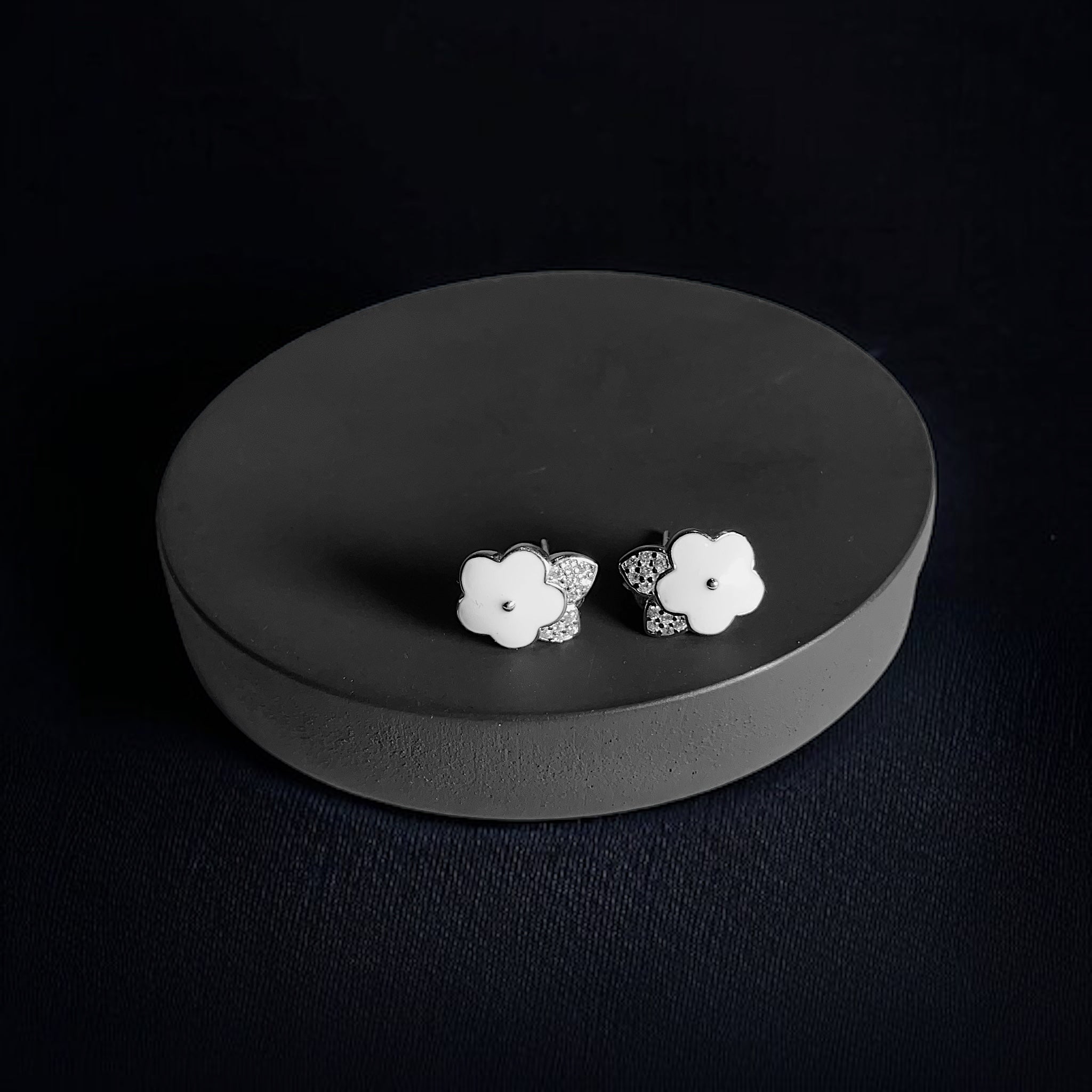 a pair of white flowers on a black plate