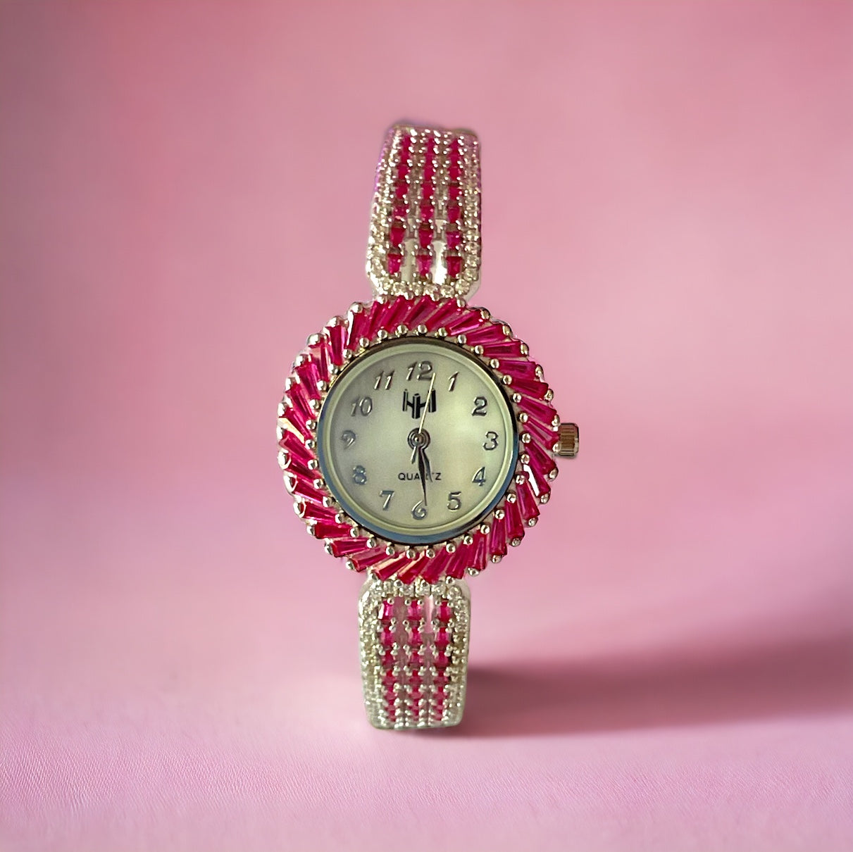 a pink watch with a white face on a pink background
